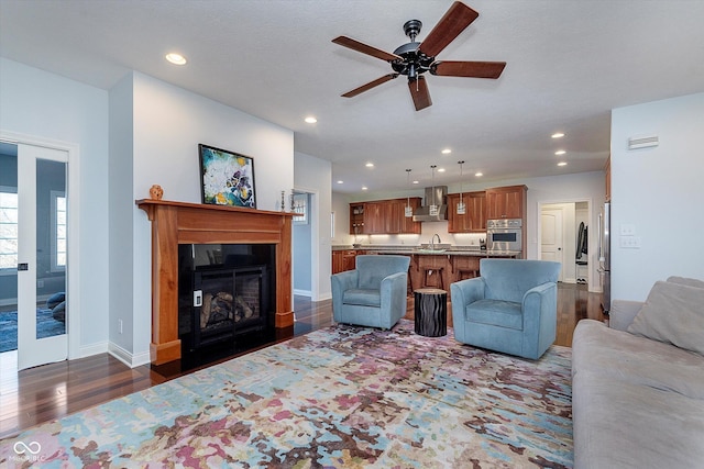 living room featuring a fireplace, dark wood finished floors, recessed lighting, visible vents, and baseboards