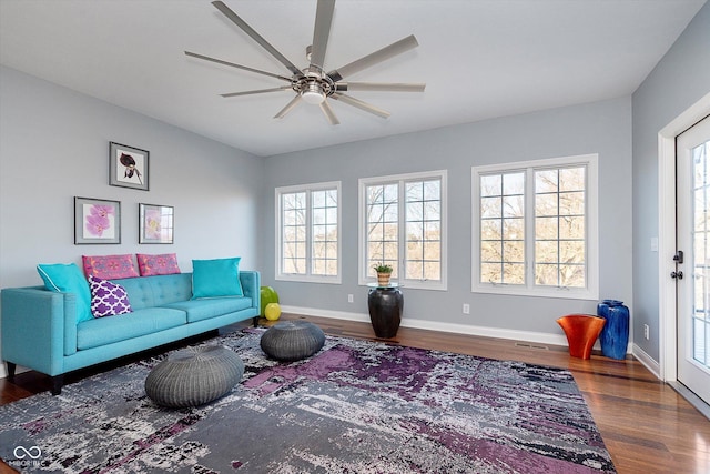 living room with visible vents, wood finished floors, a ceiling fan, and baseboards