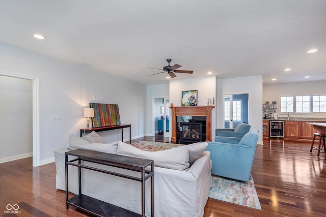 living area featuring dark wood-style floors, recessed lighting, wine cooler, and a glass covered fireplace