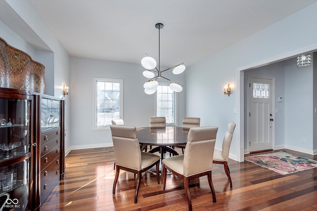 dining space featuring a chandelier, baseboards, and hardwood / wood-style floors