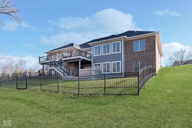 rear view of property with brick siding, a lawn, fence, a wooden deck, and stairs