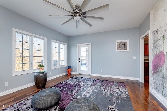 exercise room with ceiling fan, baseboards, and wood finished floors