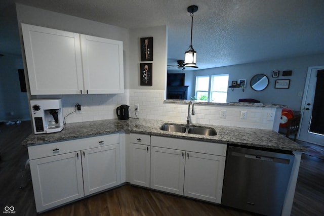 kitchen with dark wood finished floors, white cabinetry, a sink, dishwasher, and a peninsula