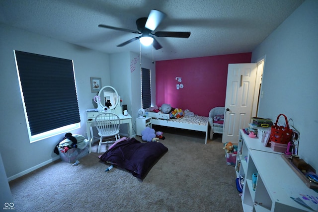 carpeted bedroom with a textured ceiling, a ceiling fan, and baseboards