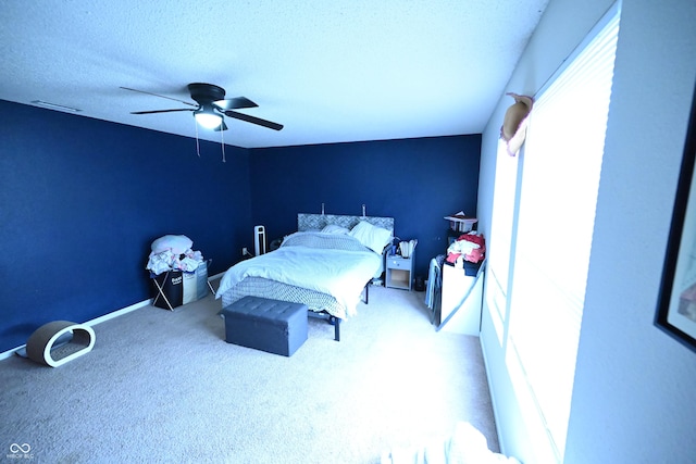 carpeted bedroom with baseboards, ceiling fan, visible vents, and a textured ceiling