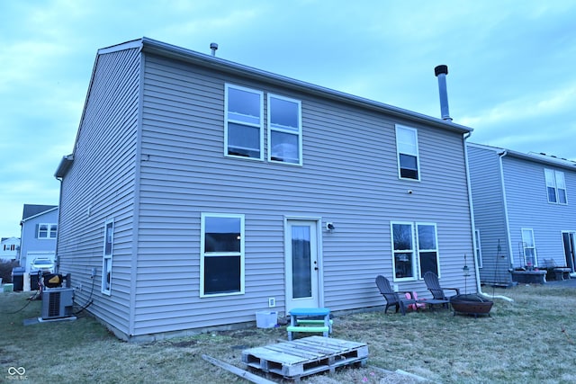 back of property with central AC and an outdoor fire pit