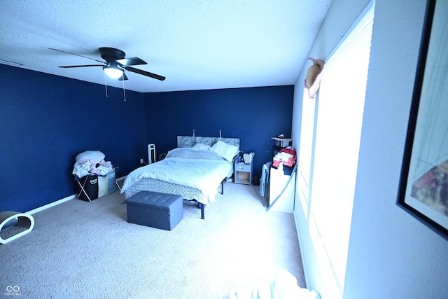 bedroom featuring a ceiling fan, carpet, and a textured ceiling