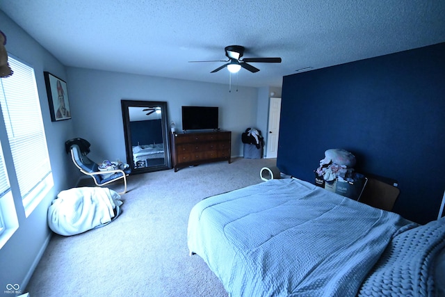 bedroom featuring carpet, a ceiling fan, and a textured ceiling