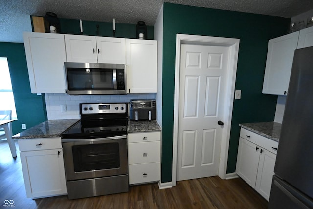 kitchen featuring dark wood-style flooring, stainless steel appliances, backsplash, white cabinets, and a textured ceiling