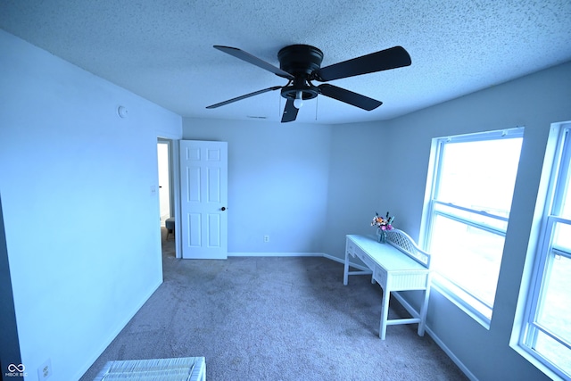 unfurnished office with carpet, a textured ceiling, and baseboards