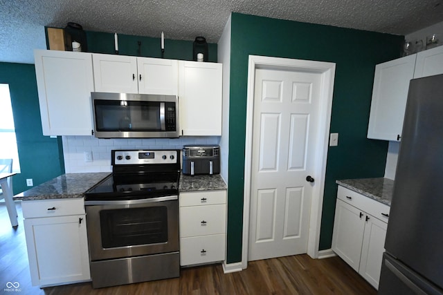 kitchen with white cabinetry, appliances with stainless steel finishes, and dark wood-style flooring