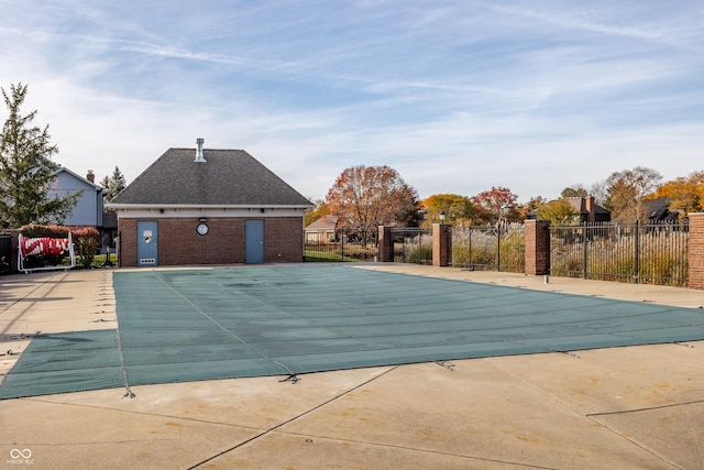 pool with a patio area and fence