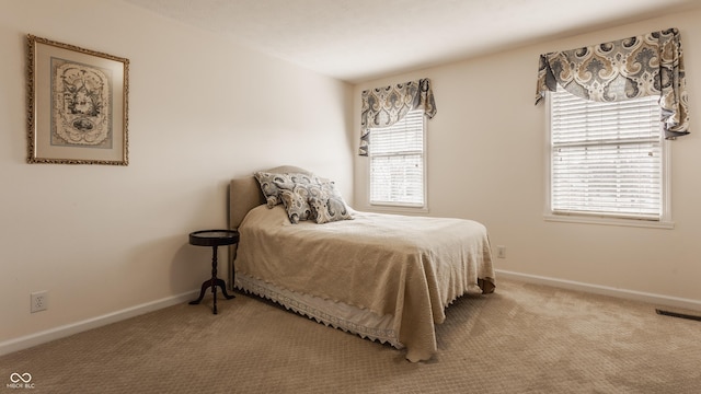 carpeted bedroom with visible vents and baseboards