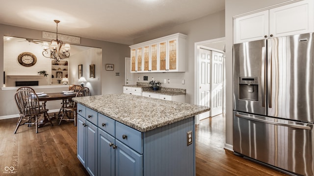 kitchen with blue cabinets, white cabinets, dark wood-type flooring, and stainless steel fridge with ice dispenser