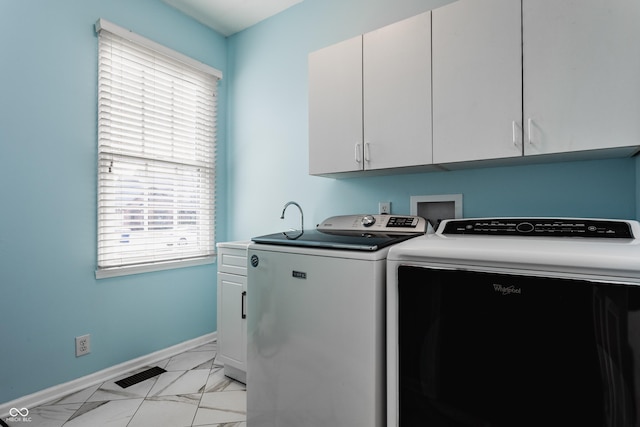 washroom with washing machine and dryer, visible vents, baseboards, marble finish floor, and cabinet space