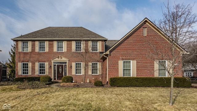 colonial home with brick siding and a front yard