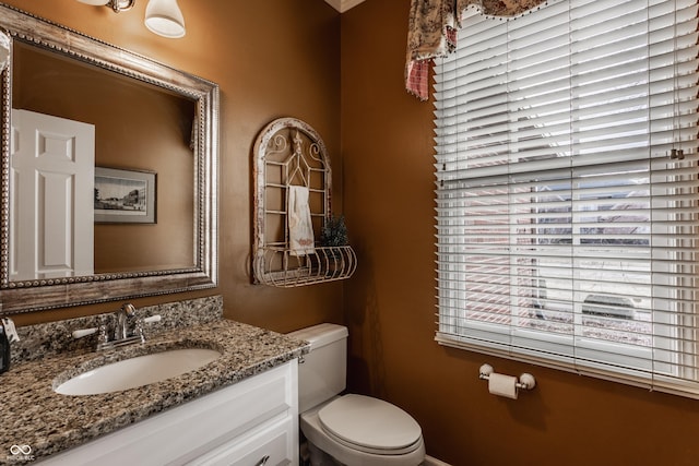 bathroom with vanity, toilet, and a healthy amount of sunlight