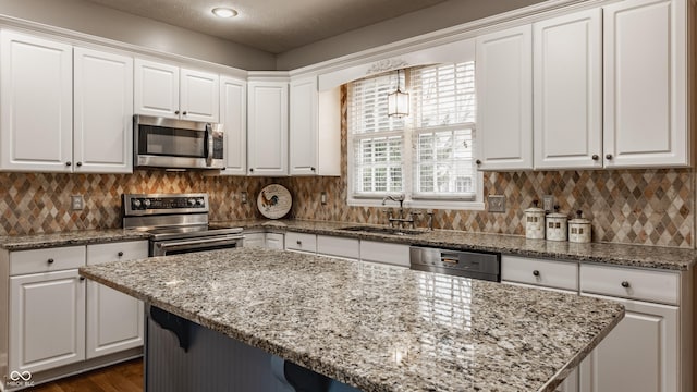 kitchen featuring stainless steel appliances, a sink, and white cabinetry