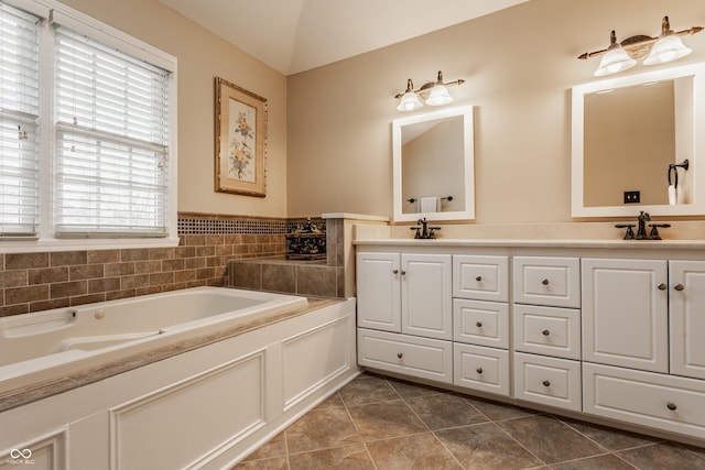 full bath with tile patterned floors, double vanity, a sink, and a bath