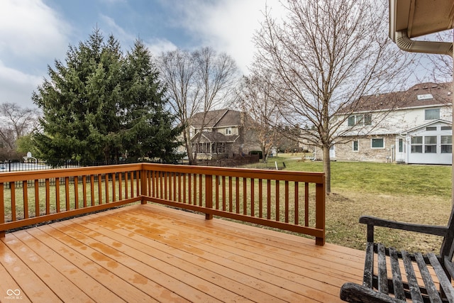 wooden terrace with a lawn and fence