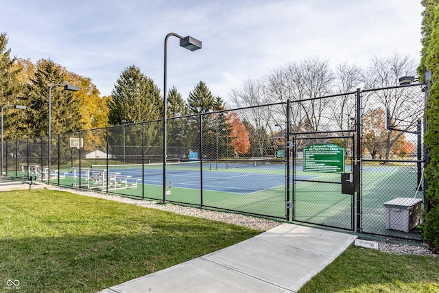 view of tennis court featuring a yard, fence, a gate, and community basketball court