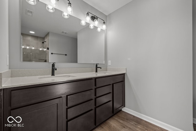 full bathroom with wood finished floors, a sink, visible vents, and baseboards