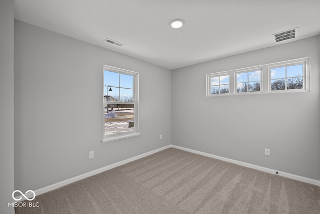 carpeted empty room with baseboards and visible vents