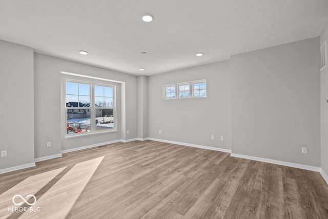 spare room featuring baseboards, wood finished floors, and recessed lighting