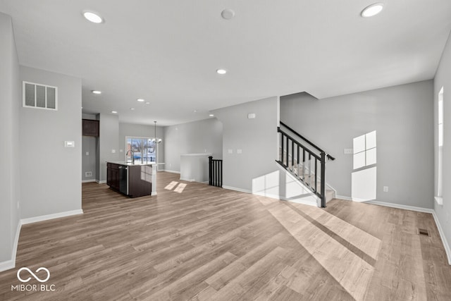 unfurnished living room with light wood finished floors, visible vents, and recessed lighting