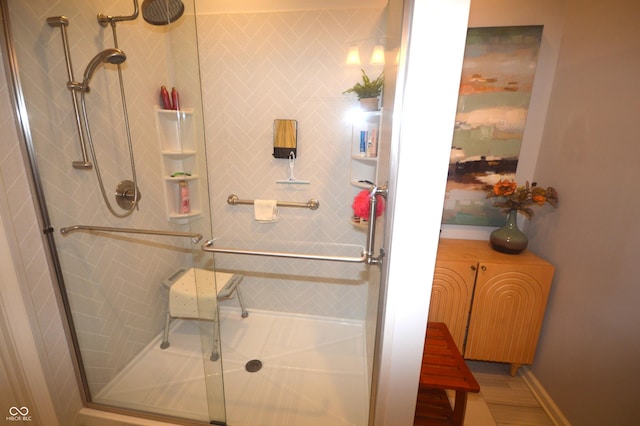 bathroom with a shower stall and baseboards