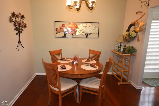 dining area featuring an inviting chandelier, baseboards, and wood finished floors