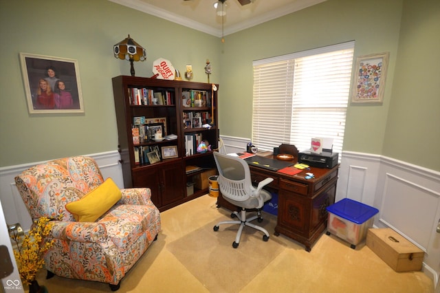 carpeted office featuring ceiling fan, ornamental molding, and wainscoting