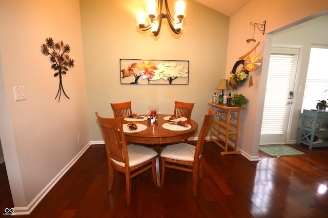 dining space featuring baseboards, an inviting chandelier, and wood finished floors