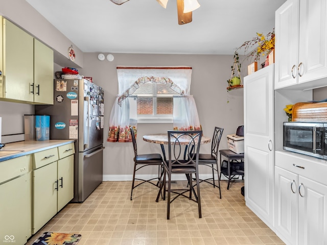 kitchen with appliances with stainless steel finishes, baseboards, light countertops, and green cabinets