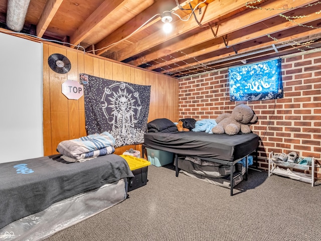 bedroom featuring carpet floors, wood walls, and brick wall