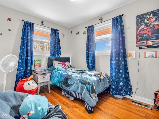 bedroom featuring multiple windows, visible vents, and wood finished floors