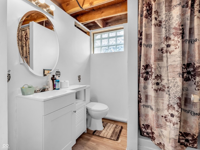 bathroom with toilet, a shower with curtain, wood finished floors, and vanity