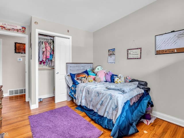 bedroom featuring wood finished floors, visible vents, and baseboards