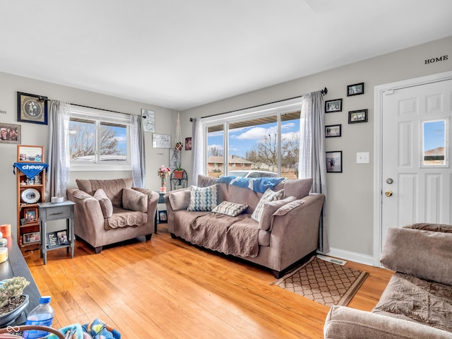 living area with light wood-type flooring and baseboards