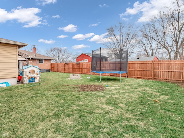 view of yard featuring a trampoline and a fenced backyard