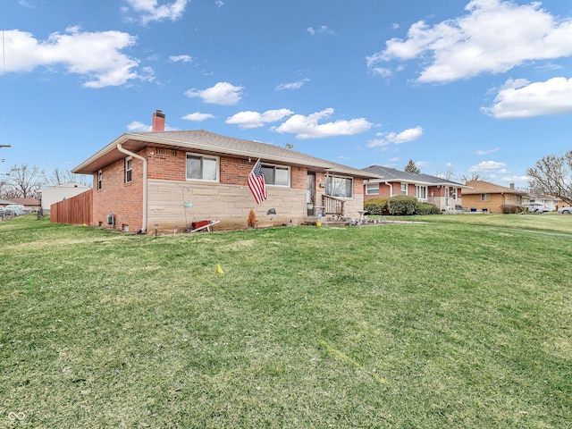 ranch-style home featuring brick siding, a chimney, and a front lawn