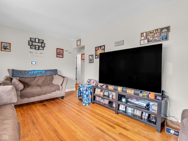 living area with baseboards and wood finished floors