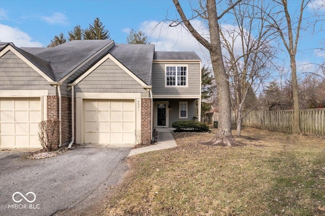 view of front of house with an attached garage, fence, aphalt driveway, and brick siding