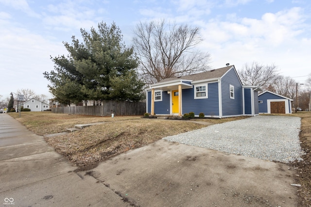 bungalow featuring a garage, fence, driveway, and an outdoor structure