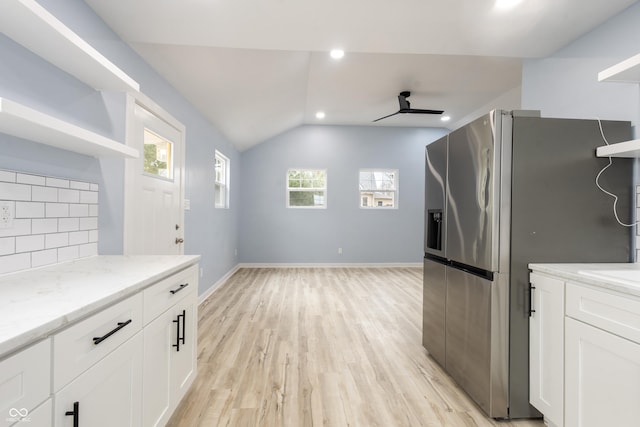 kitchen with light wood-style flooring, white cabinetry, open shelves, tasteful backsplash, and stainless steel fridge