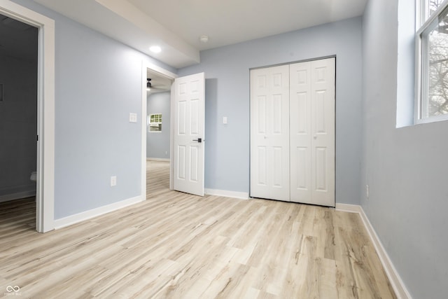 unfurnished bedroom with light wood finished floors, baseboards, a closet, and recessed lighting