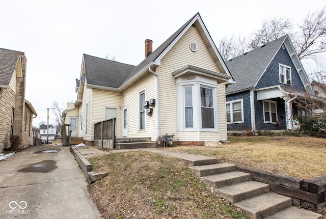 view of front of home featuring roof with shingles and a chimney