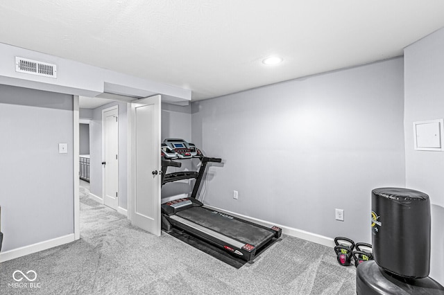 exercise room featuring carpet flooring, visible vents, and baseboards