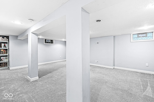 below grade area featuring carpet floors, visible vents, and baseboards