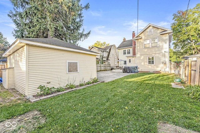 rear view of property featuring a patio area, a yard, and a fenced backyard